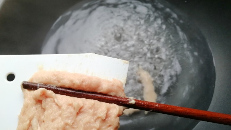 福鼎肉片,水开后，用筷子将肉泥如图一样刮到锅里的开水中