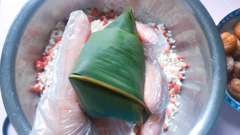 花生蜜枣粽,顺着边边将粽叶折好；