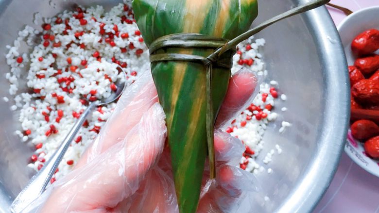红豆红枣牛角粽,最后用粽绳扎紧打结，一个酷似牛角的粽子就完成啦。