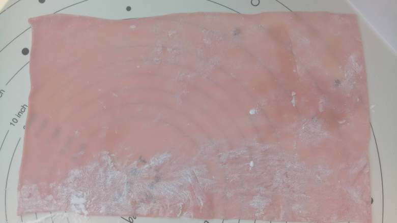 樱桃白玉卷,硅胶垫上撒点玉米淀粉，把外皮擀成与模具等宽的长方形（长度正好能包裹一周为宜）。
