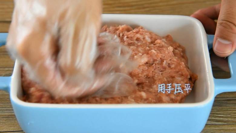 肉饼蒸蛋—从小吃到大的美味,肉馅装入碗中，用手压平。