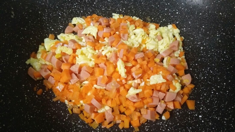 来一份不一样的蛋炒饭,把切好的胡萝卜和火腿倒进锅里翻炒一下。