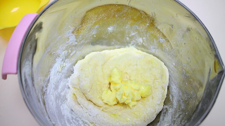 简单易学的早餐面包,慢慢加入温水，戴上一次性手套揉成团后，加入软化好的黄油继续揉面