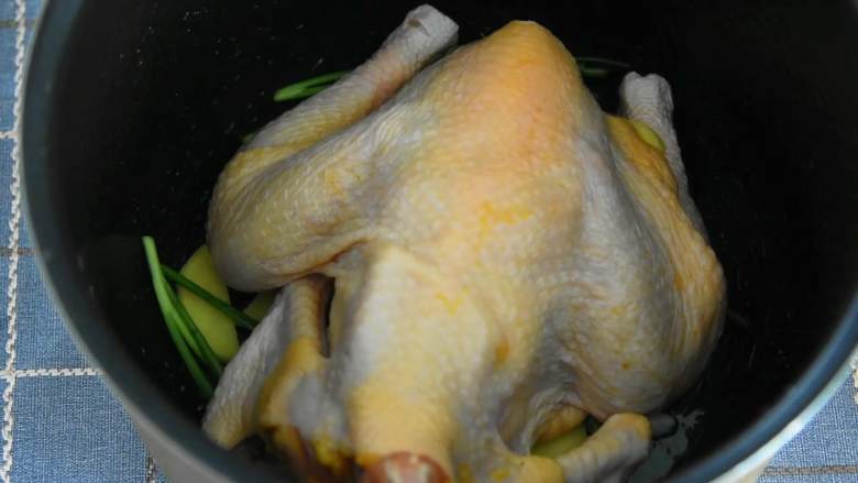 电饭煲盐焗鸡—一滴水都不加，做出来的鸡却嫩滑多汁,放入腌制好的鸡。
刷层油，合上盖子，煮30~40分钟。