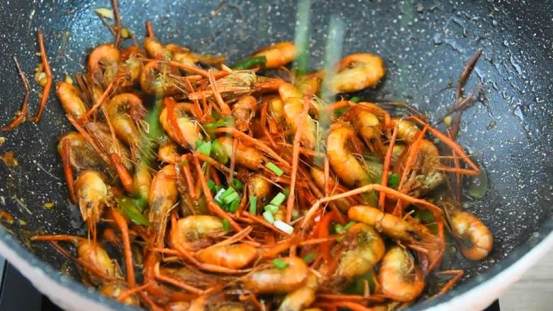 油爆虾—火爆杭州的老头儿油爆虾，自己在家也能做,加1勺盐、3大勺糖，炒匀后撒入葱花即可。