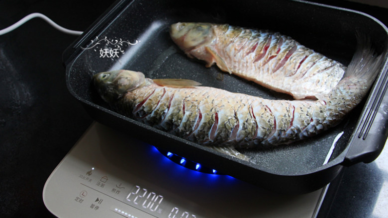 香辣烤鱼,煮蔬菜的时候来煎鱼，准备一个韩式烤盘，直接在烤盘里加入油，烧热后摆入草鱼来煎。
