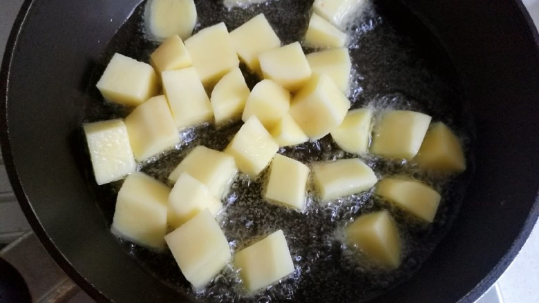 土豆红烧排骨,锅中放油烧热，放入土豆炸一下，炸过的土豆颜色好，口感也酥香。