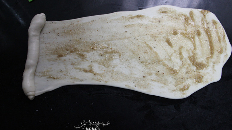 人气油酥饼,抹上均匀的一层油酥，从左往右滚动卷起来，边卷边拉，面团醒过后可以拉出很长。