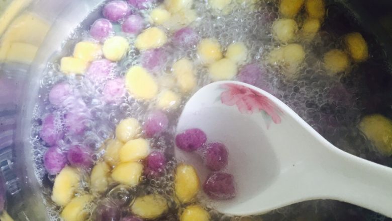 治愈系甜品+桃胶双色芋圆水果捞,用汤勺搅匀一下防止粘锅底，再煮片刻，芋圆浮出水面即可