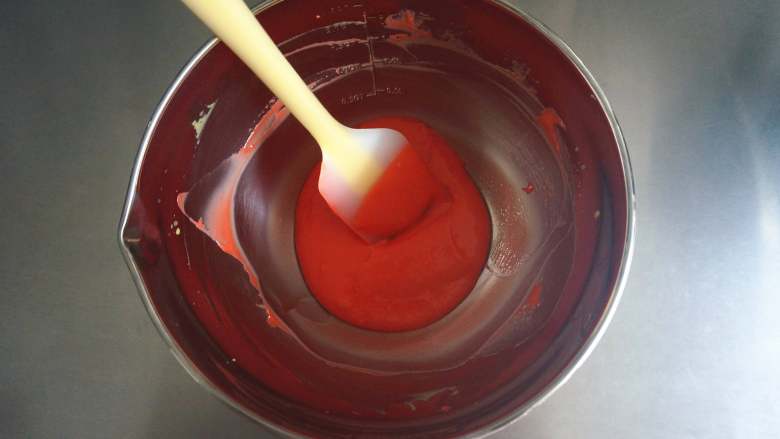 夏季私房热门的西瓜蛋糕,加入几滴红色素，拌均匀，将红色的蛋黄糊放置一旁备用。此时，150度上下火开始预热烤箱。
