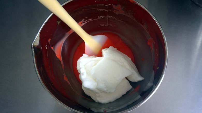 夏季私房热门的西瓜蛋糕,将三分之一的蛋白糊加入到红色蛋黄糊中，翻拌均匀。
