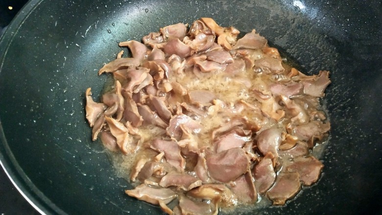 双椒鸭胗,炒至变色，这个时候会炒出很多的汁水，把鸭胗盛出来，汁水不要，备用。