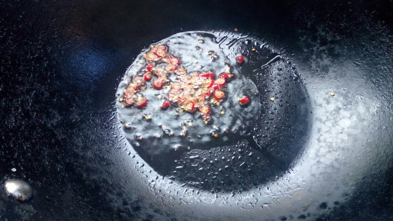白灼金针菇,锅里加入适量的食用油，待油烧热后，倒入小米椒略微翻炒，炒出辣味后关火。