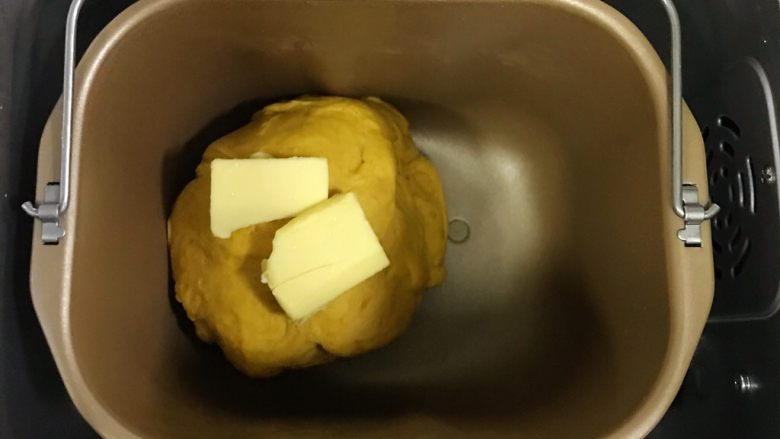 全麦南瓜牛角包,揉至约15分钟面团成型，加入黄油继续揉面20分钟至扩展阶段，可以拉出薄膜即可。