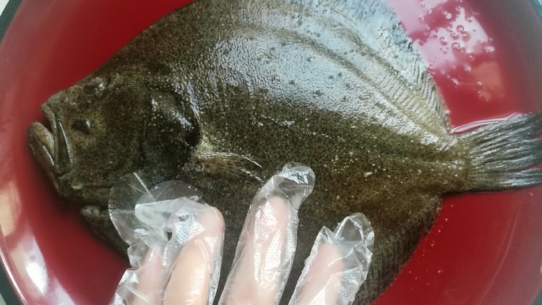 清蒸多宝鱼,戴上一次性手套，在鱼身上涂抹均匀，腌制二十分钟备用。