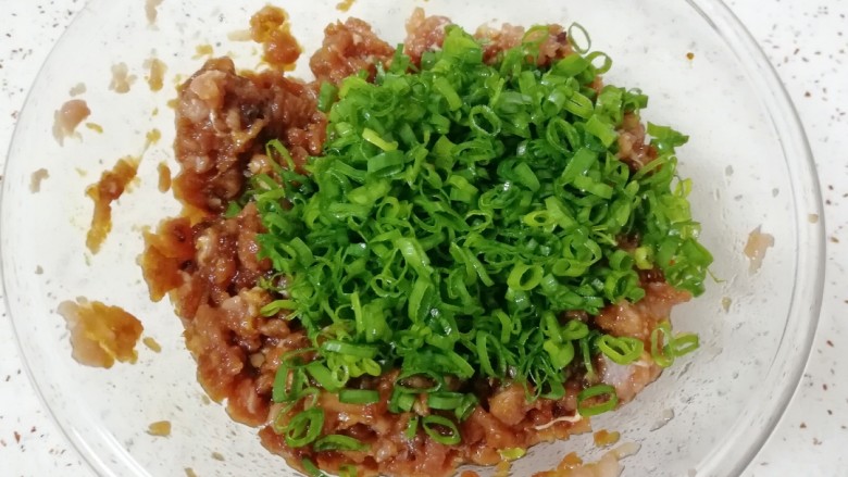 胡萝卜香菇肉馅小笼包,做好的肉馅里加入香葱叶搅拌均匀。