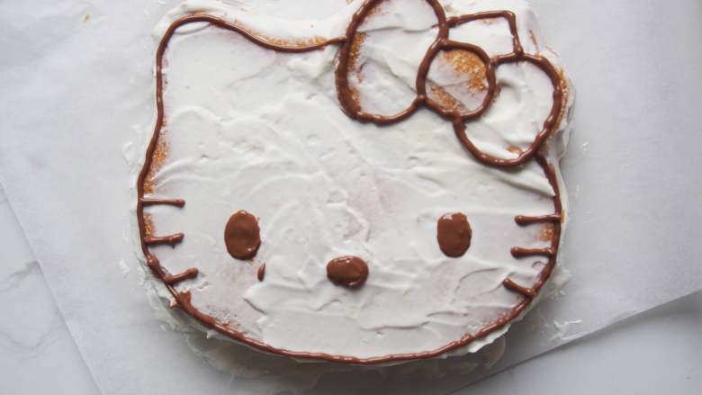 Hello Kitty 奶油蛋糕,<a style='color:red;display:inline-block;' href='/shicai/ 874'>巧克力</a>融化后装入裱花袋，剪开小口，沿着蛋糕边缘画出形状。