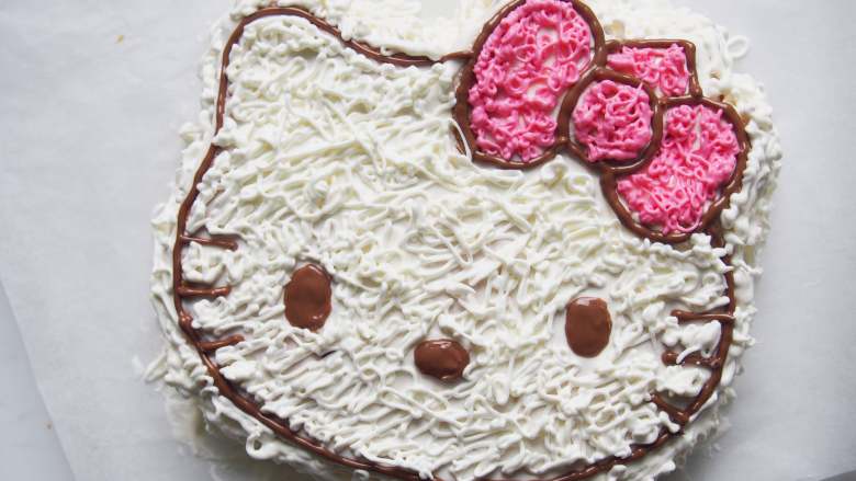 Hello Kitty 奶油蛋糕,用粉色色素调出蝴蝶结的颜色， 将淡奶油装入裱花袋中，剪开一个小口，挤出条纹状的奶油布满蛋糕即可。