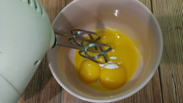 蛋黄溶豆,用打蛋器把蛋黄打发。