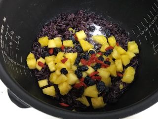 香甜菠萝糯米饭,黑加仑和枸杞用清水冲洗，沥干水分，然后加入煮好的糯米饭中，以及再加入细砂糖。