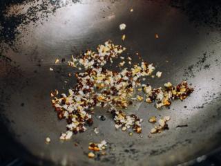 干煸四季豆,把油从锅里舀出来，剩一勺。把火调小，加入花椒、生姜、大蒜。