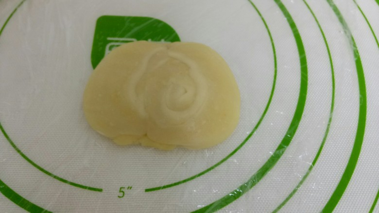 苏式椒盐月饼,然后再取一个卷，用拇指从中间按下，两头往中间捏，然后压扁。