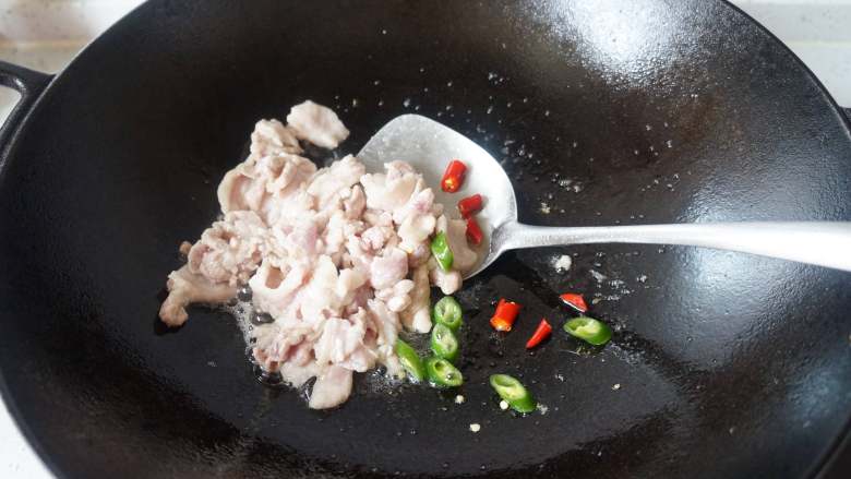泡菜豆腐汤,热锅凉油倒入五花肉翻炒几下，放入辣椒翻炒至肉变色