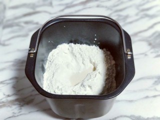 超级松软-零失败的豆沙吐司面包,加入高筋面粉，再面粉的顶端挖个小洞，(注意不要挖到液体) 然后把酵母粉倒入挖好的小洞里。再将莲藕盖起来。