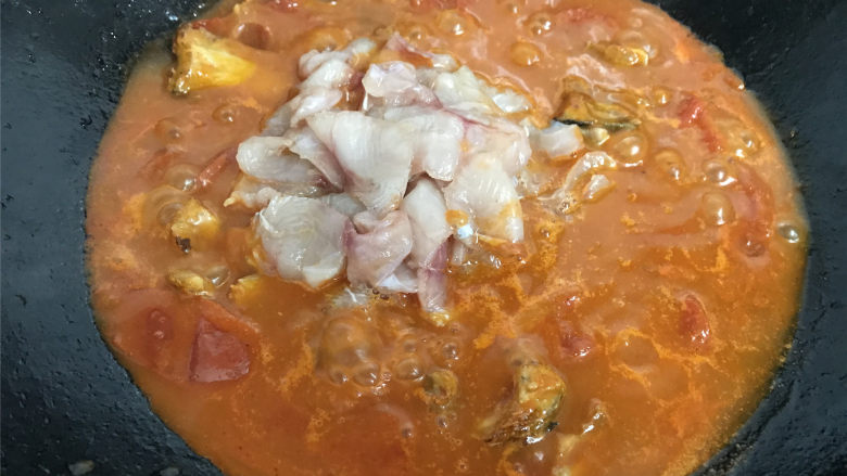 番茄鱼,煮至汤浓稠再把腌好的鱼肉放入一起煮。