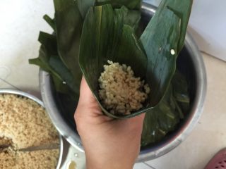 香香肉粽,加入一勺糯米，用筷子捅紧米粒