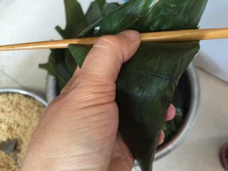 香香肉粽,再加入一勺糯米，将两边叶子向里收拢，上边叶面向下压下盖住不漏米粒