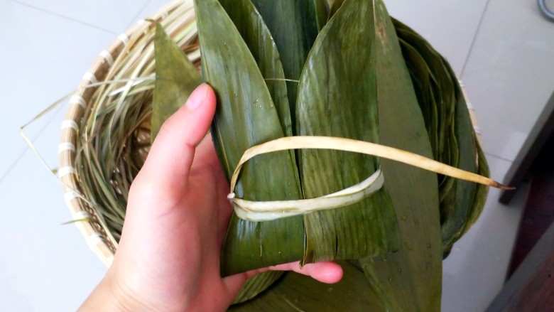不同类型粽子的包法,用绳子把下端固定住。