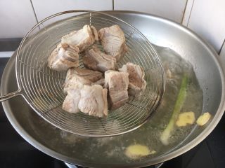 梅菜排骨煲,锅里放入大量的凉水，放入姜片和葱段，放入排骨，水开后捞出排骨备用。