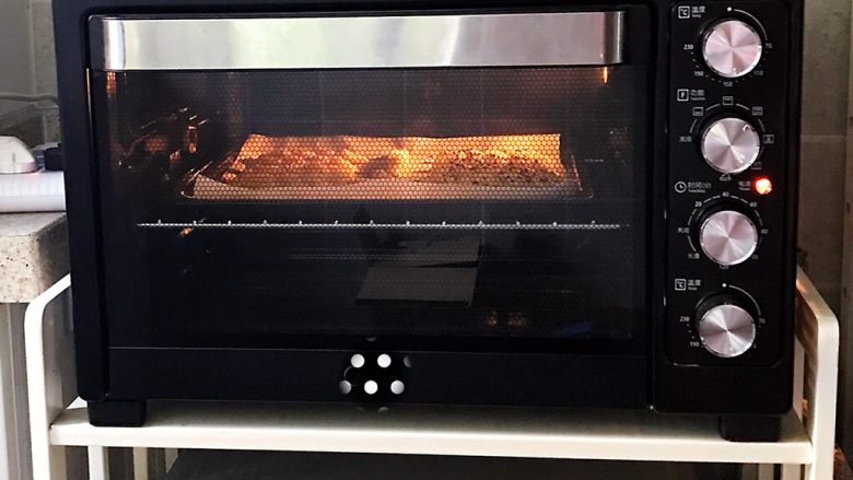 蜂蜜芝麻小麻花,烤箱预热160度，将麻花放入烤箱中层，上下火烤15分钟左右，熄火后焖15分钟取出