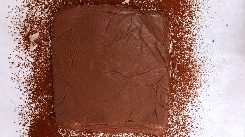 超好吃的生巧克力,把定型的巧克力脱模倒扣在油纸上，撕下保鲜膜