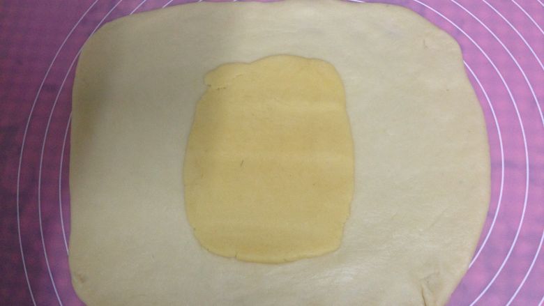 奶盐苏打饼干,油酥面团放在水油皮面团上压扁，用擀面杖压一压，使它以扁平的状态铺在水油皮中间