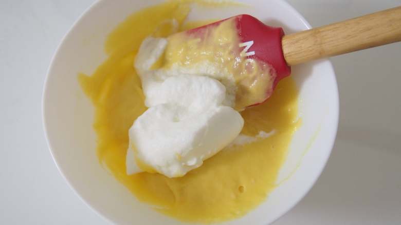 栗香椰蓉小贝,取三分之一蛋白加入蛋黄糊中，切拌均匀。
