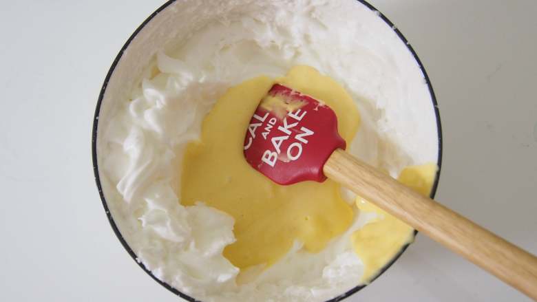 栗香椰蓉小贝,将蛋黄糊倒入蛋白中，切拌均匀。