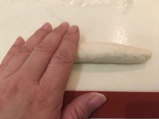 奶酪面包圈,此时面团已成条状，双手一起将条状搓平滑变长