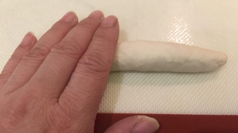 奶酪面包圈,此时面团已成条状，双手一起将条状搓平滑变长