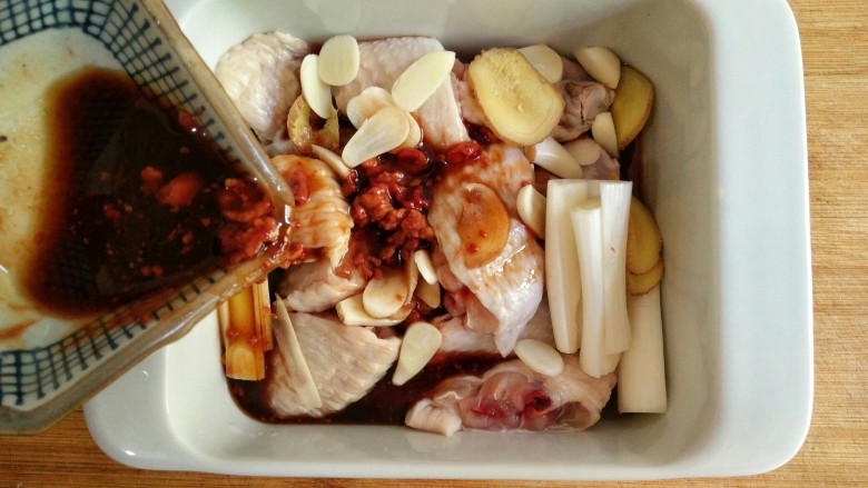 香菇蒸鸡翅,将切好的鸡翅中放入烤盘中，放入葱姜蒜，倒入调好的料汁。
