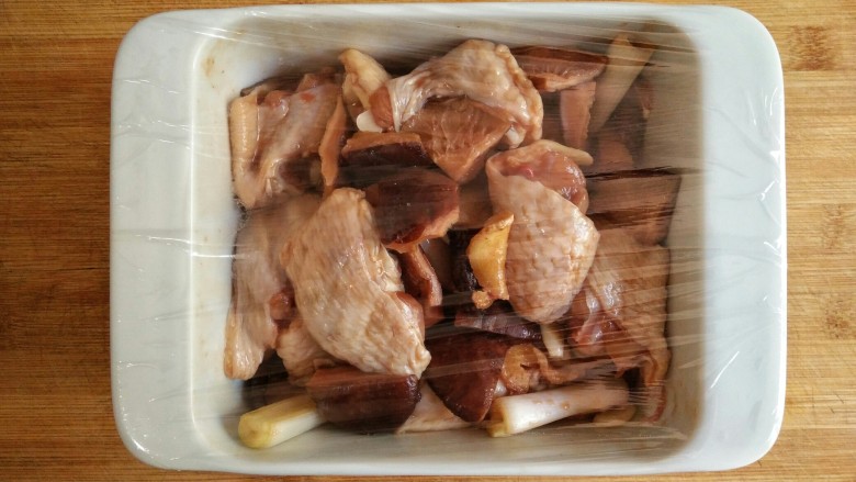 香菇蒸鸡翅,然后在烤盘上盖一层保鲜膜。