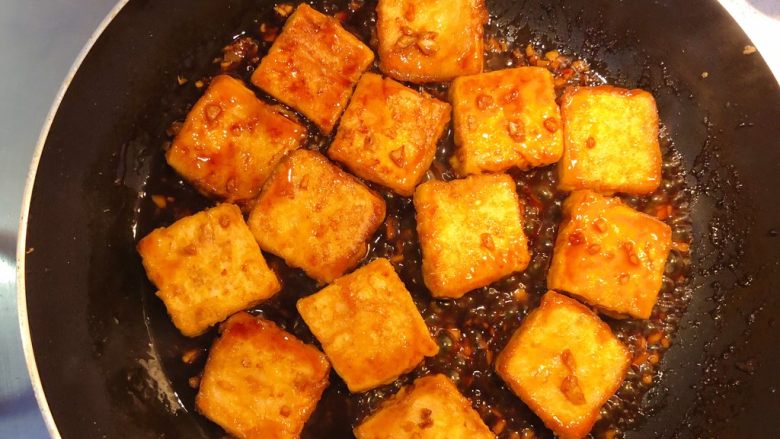 红烧豆腐（锅塌豆腐）,加入煎好的豆腐块，把汤汁烧开，再将豆腐翻面，全部裹匀。