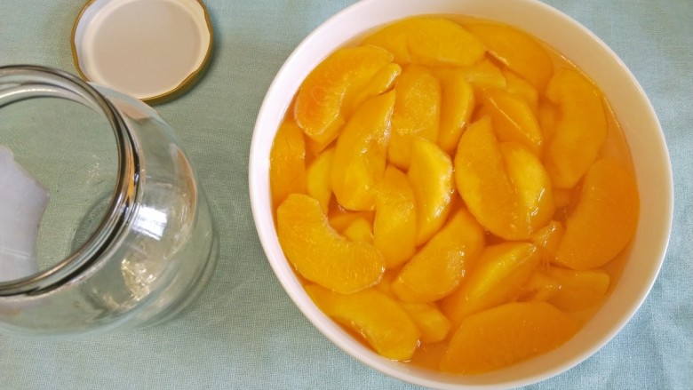 自制黄桃罐头,玻璃瓶提前用开水消毒晾干，黄桃趁热装入消毒过的玻璃瓶中，立即盖上盖子并扭紧