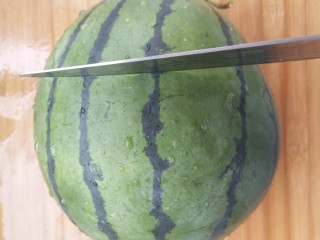 学一种西瓜的有爱吃法,把西瓜从中间切开。