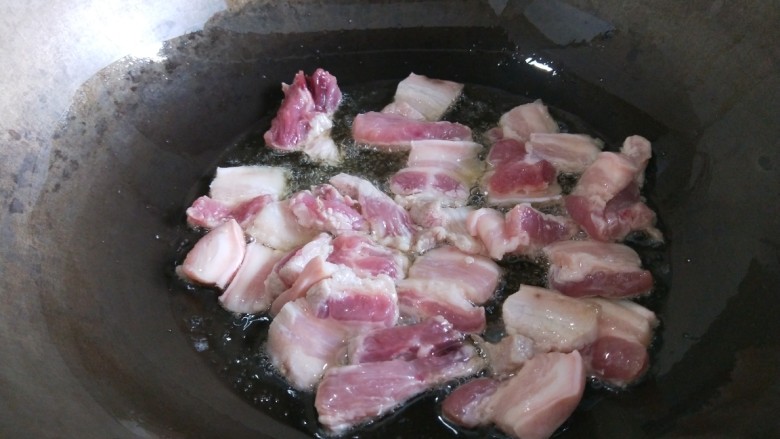 猪肉炖海带丝,锅中放适量油烧热，倒入五花肉煸炒。