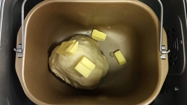 椰蓉奶香面包棒,揉至约15分钟面团成型，加入黄油继续揉面20分钟至扩展阶段。