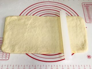 椰蓉奶香面包棒,用擀面杖慢慢擀开，呈大一些的长方形。