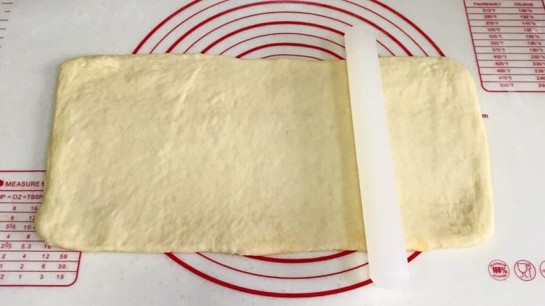 椰蓉奶香面包棒,用擀面杖慢慢擀开，呈大一些的长方形。