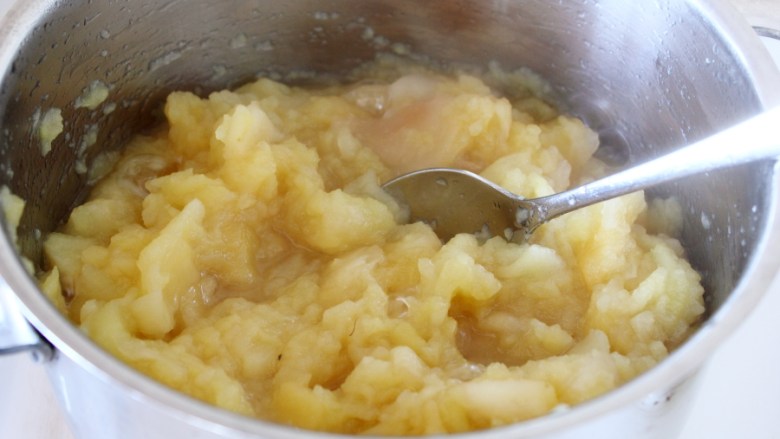 苹果酱,水份减少，取一勺子，划散一下（但不要操底），苹果即成为小的颗粒，但还有个别的有点硬，盖锅继续熬。
